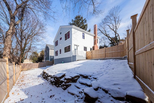 view of snow covered rear of property