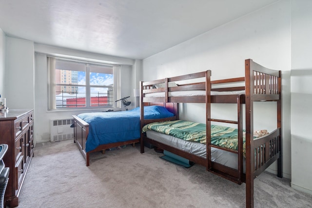 bedroom with radiator heating unit and light colored carpet