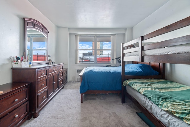 bedroom with light colored carpet, radiator, and multiple windows