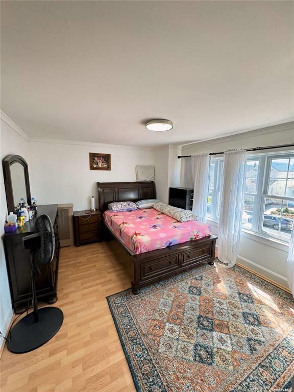 bedroom featuring light hardwood / wood-style floors and ornamental molding