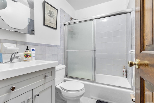 full bathroom with vanity, toilet, enclosed tub / shower combo, and tile walls