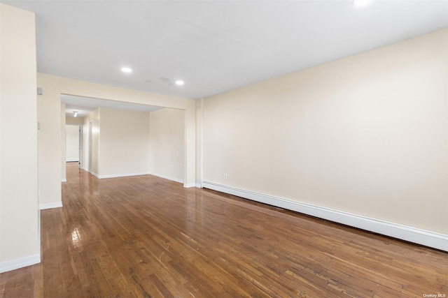 spare room with hardwood / wood-style flooring and a baseboard radiator