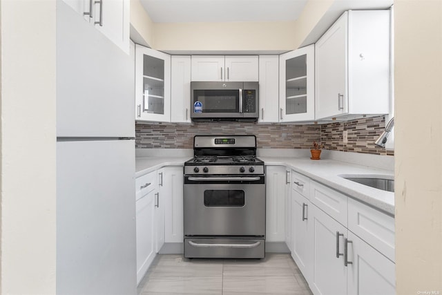 kitchen featuring white cabinets, decorative backsplash, sink, and appliances with stainless steel finishes