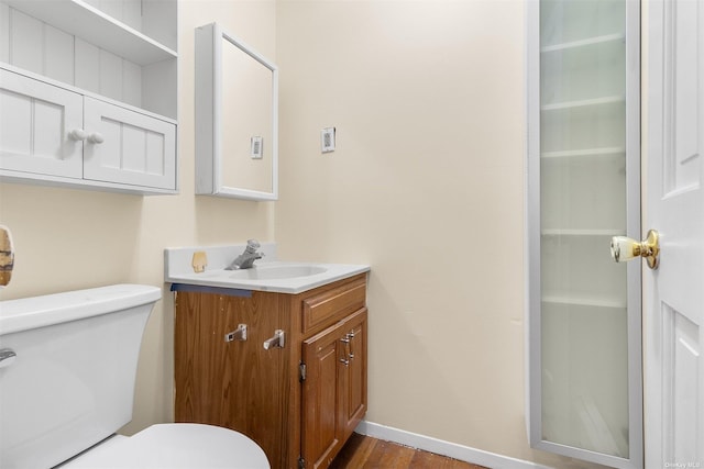 bathroom with hardwood / wood-style flooring, vanity, and toilet