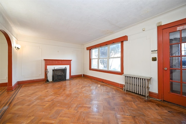 unfurnished living room featuring parquet floors and radiator