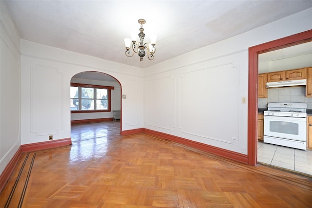 unfurnished dining area featuring light parquet floors and a notable chandelier