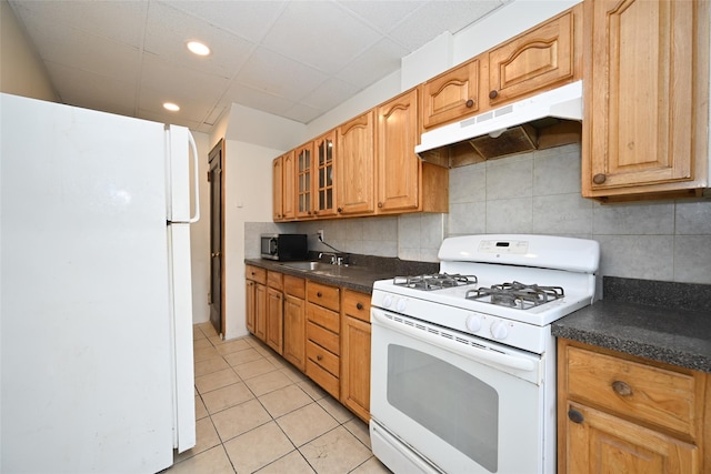 kitchen with sink, white appliances, backsplash, and light tile patterned floors