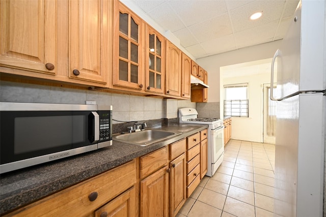 kitchen with light tile patterned floors, white appliances, backsplash, and sink