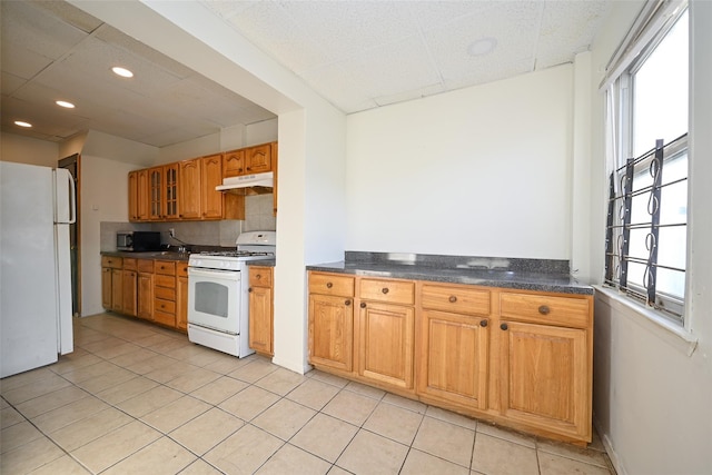 kitchen featuring light tile patterned flooring, white appliances, plenty of natural light, and backsplash