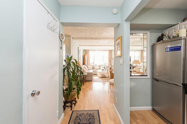 hallway featuring light wood-type flooring and baseboards