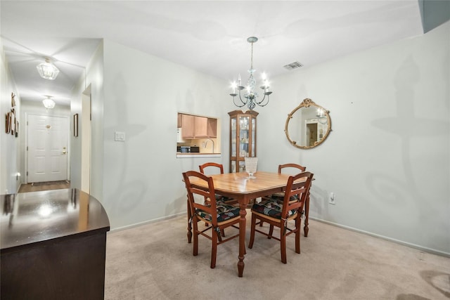 carpeted dining space with an inviting chandelier