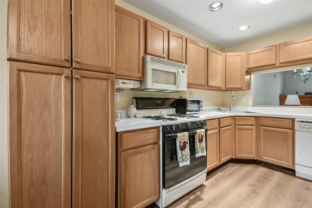 kitchen with light brown cabinetry, white appliances, light hardwood / wood-style floors, and sink