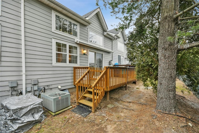 rear view of property with a wooden deck and cooling unit