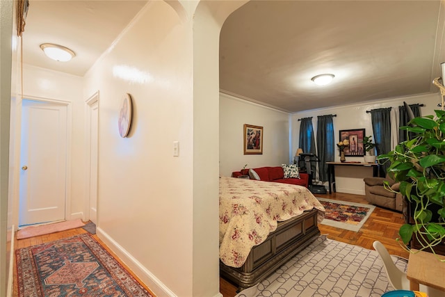 bedroom with crown molding and light parquet flooring