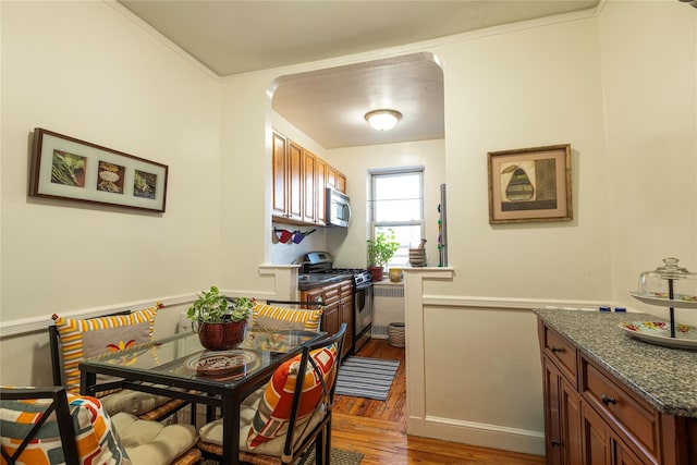 dining space featuring crown molding and dark hardwood / wood-style flooring