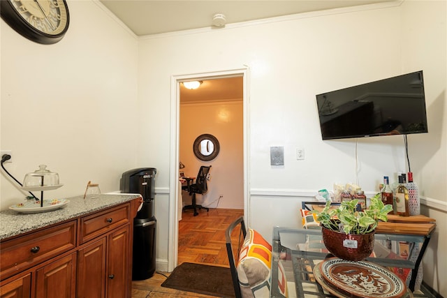 kitchen with light stone counters, crown molding, and light parquet flooring