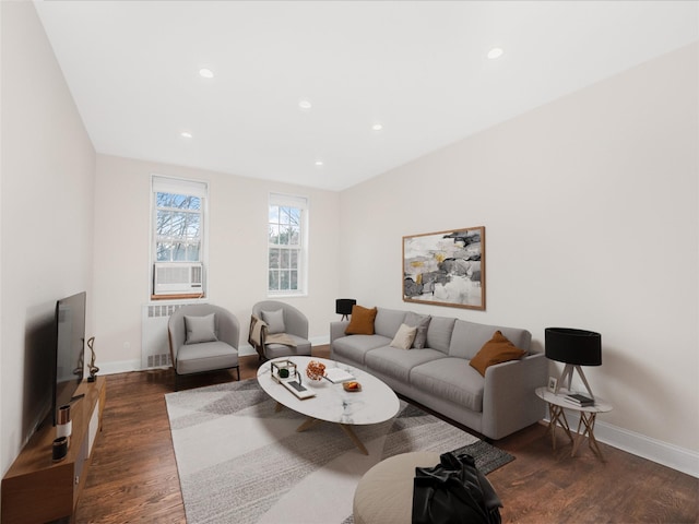 living room featuring dark hardwood / wood-style flooring, cooling unit, and radiator heating unit