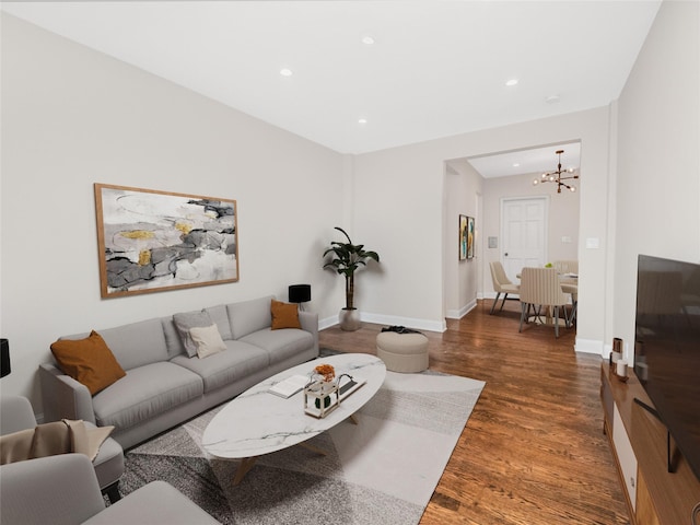 living room with dark wood-type flooring and a chandelier