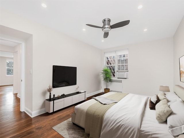 bedroom with ceiling fan, radiator, and dark hardwood / wood-style floors