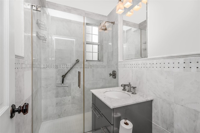 bathroom with tile walls, a shower with door, and vanity