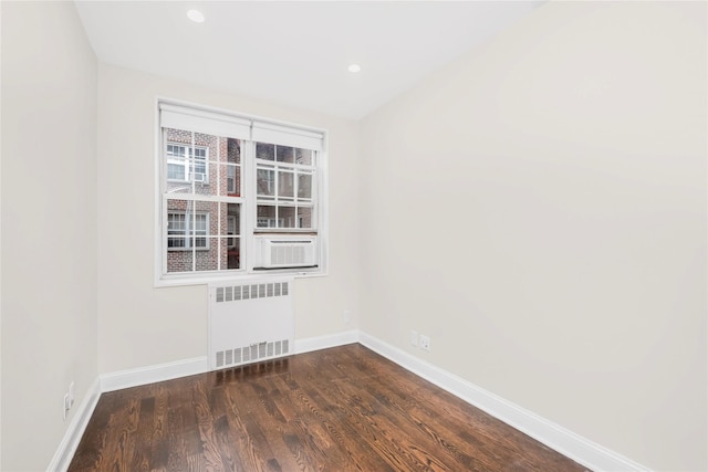 empty room featuring radiator and dark hardwood / wood-style flooring