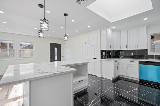 kitchen with light stone countertops, hanging light fixtures, white cabinets, and a kitchen island