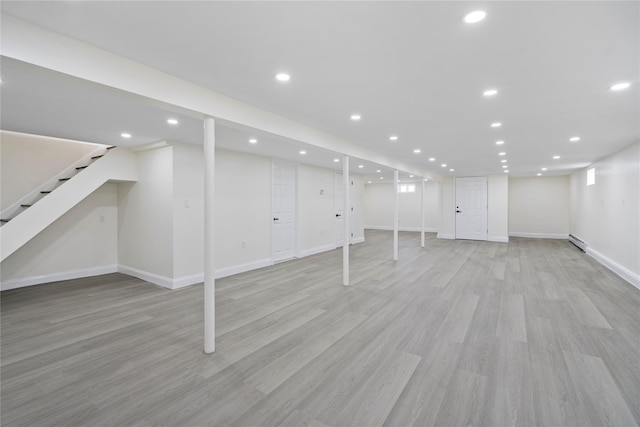 basement with a baseboard radiator and light wood-type flooring