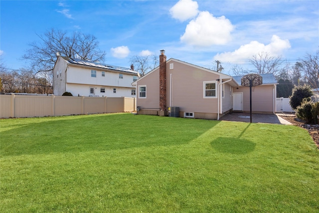 rear view of property featuring central AC unit and a yard