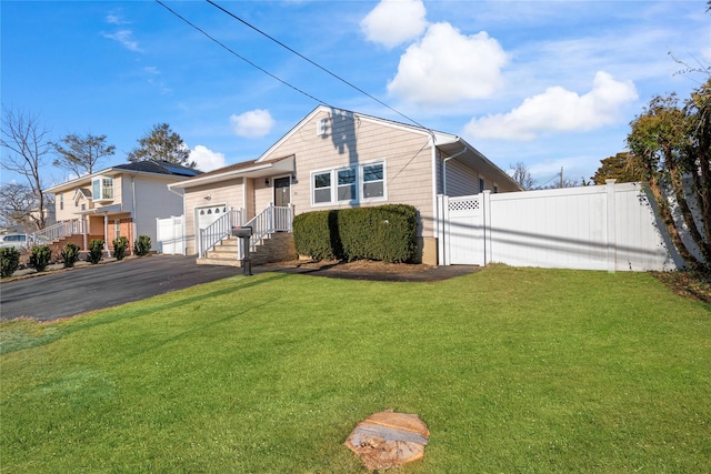 view of front of home featuring a front yard and a garage