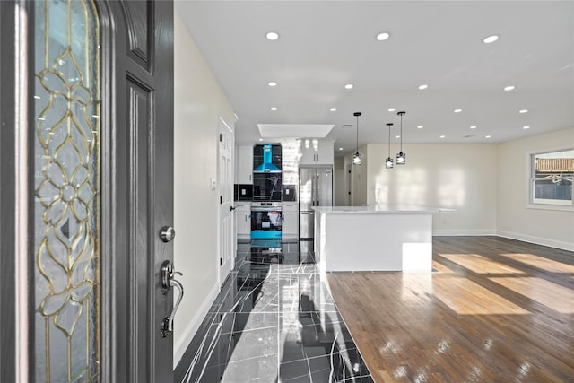 kitchen with white cabinetry, pendant lighting, extractor fan, and a kitchen island