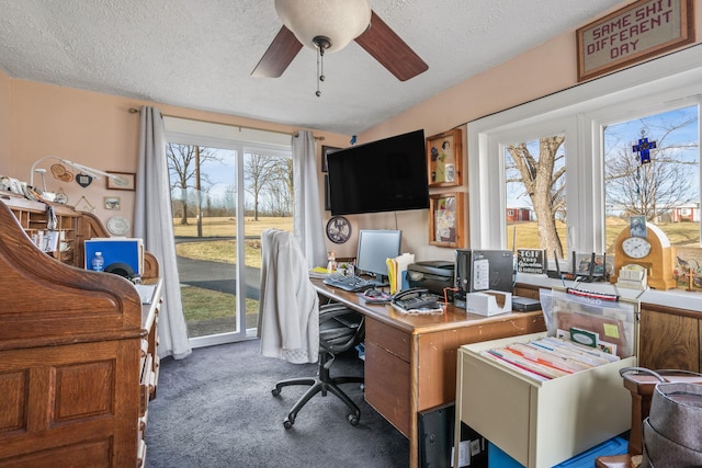 office area with ceiling fan, a textured ceiling, and dark carpet