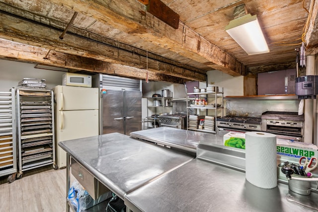 kitchen featuring premium appliances, light wood-type flooring, and stainless steel counters