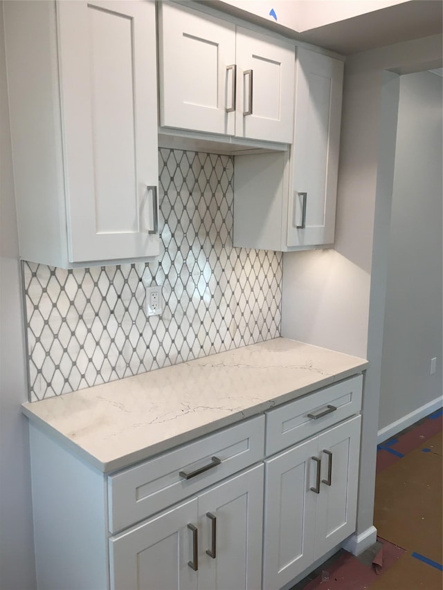 kitchen featuring decorative backsplash and light stone countertops