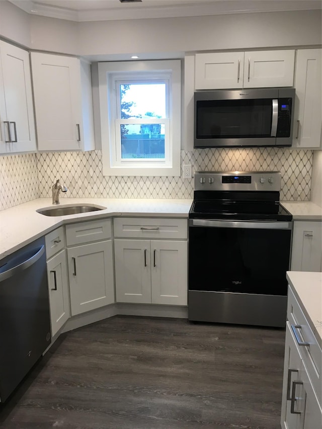 kitchen featuring dark wood-type flooring, white cabinets, appliances with stainless steel finishes, and sink