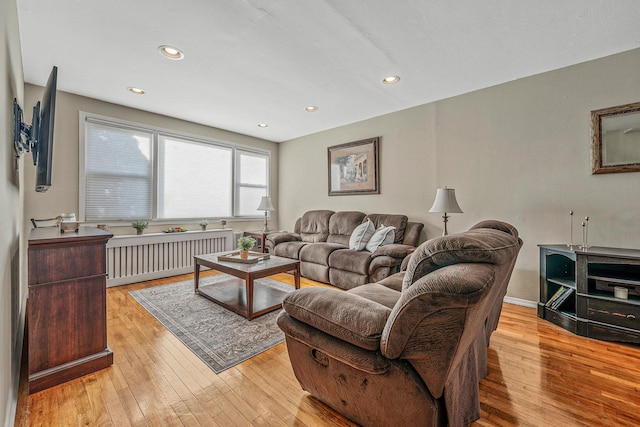 living room with radiator heating unit and light hardwood / wood-style flooring