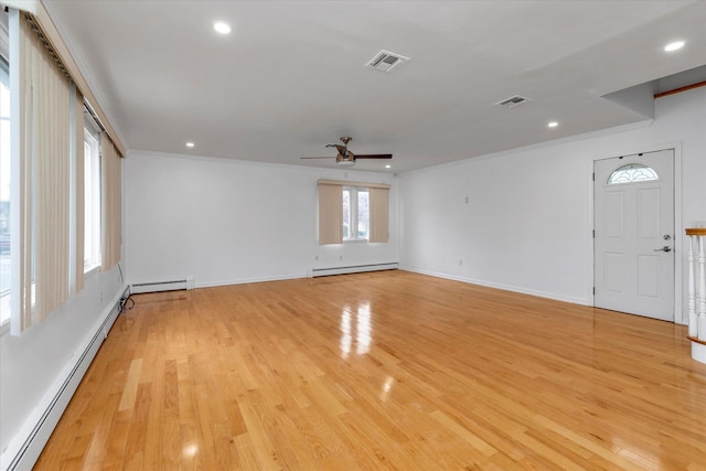 unfurnished room featuring light hardwood / wood-style flooring, baseboard heating, and crown molding