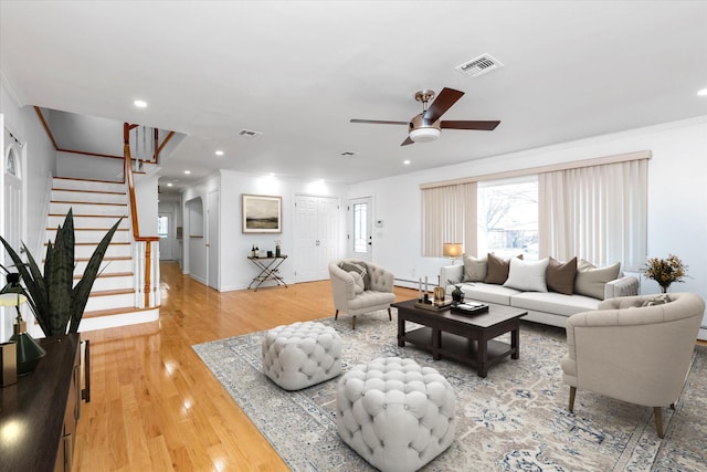 living room with ceiling fan, a baseboard heating unit, and wood-type flooring