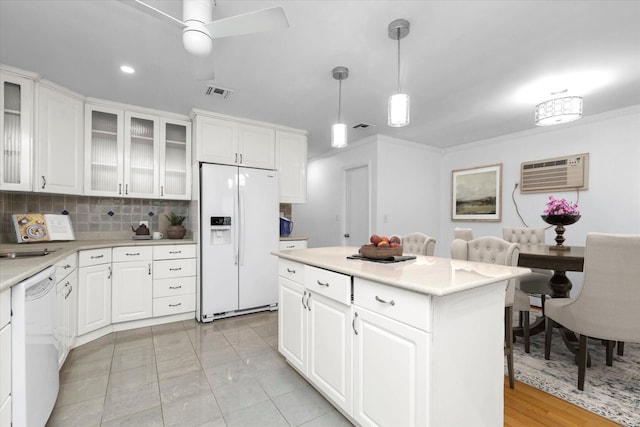 kitchen with decorative light fixtures, white cabinetry, white appliances, a wall mounted air conditioner, and a center island