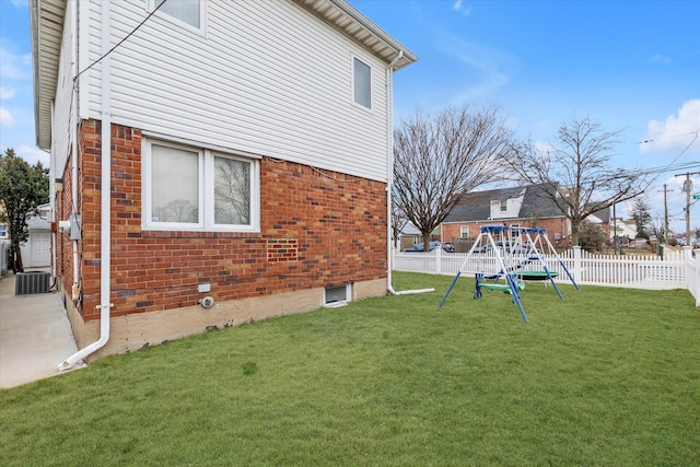 view of side of home with a playground, central AC unit, and a lawn