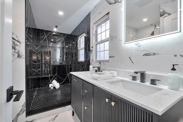 bathroom with vanity and a tile shower