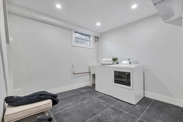 laundry room with dark tile patterned floors and washing machine and dryer