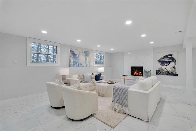 living room featuring a high end fireplace and plenty of natural light