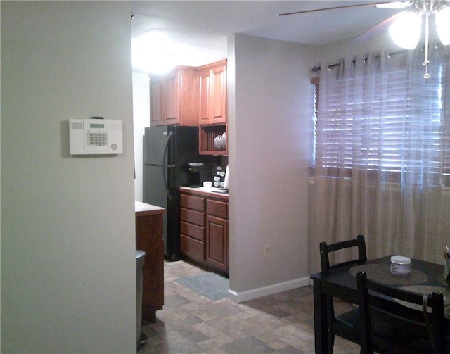 kitchen featuring ceiling fan and black fridge