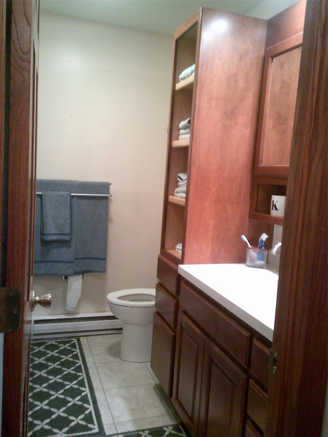 bathroom with baseboard heating, toilet, tile patterned flooring, and vanity