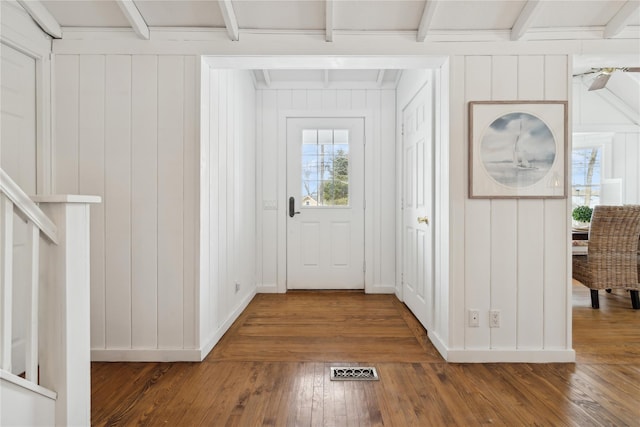 doorway to outside featuring hardwood / wood-style flooring and beamed ceiling