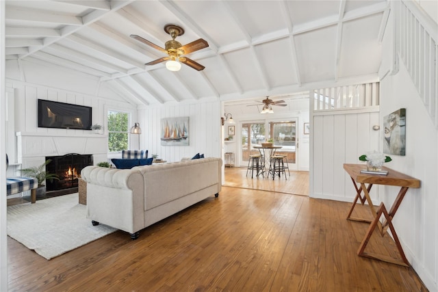 living room featuring wood-type flooring, vaulted ceiling with beams, and ceiling fan