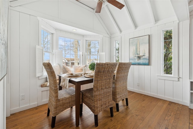 dining room featuring ceiling fan, wood-type flooring, and vaulted ceiling with beams