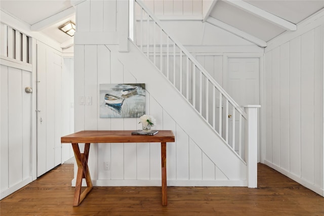 stairs with hardwood / wood-style floors and lofted ceiling with beams