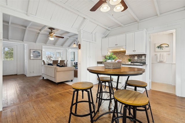 dining area with lofted ceiling with beams, light hardwood / wood-style flooring, and ceiling fan