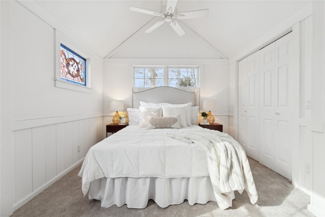 bedroom featuring ceiling fan, lofted ceiling, a closet, and light carpet